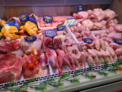 “Refrigerated counter at Santa Catalina Market in Palma de Mallorca, displaying whole chickens, rabbit, wings, and various fresh cuts of meat with price tags.”