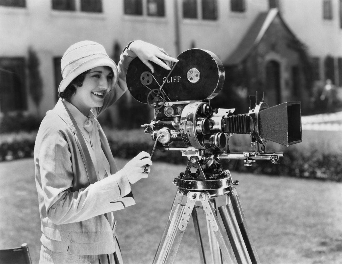 Black&white of a woman operating a film camera in the early 20th century