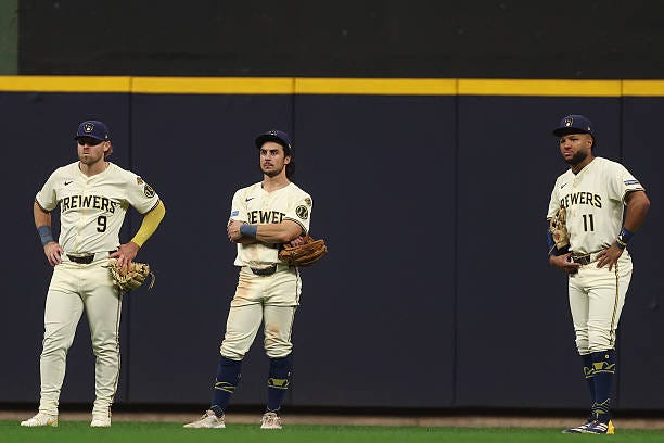 Jake Bauers, Sal Frelick, and Jackson Chourio of the Milwaukee Brewers look on during the ninth inning against the Los Angeles Dodgers in game two of...