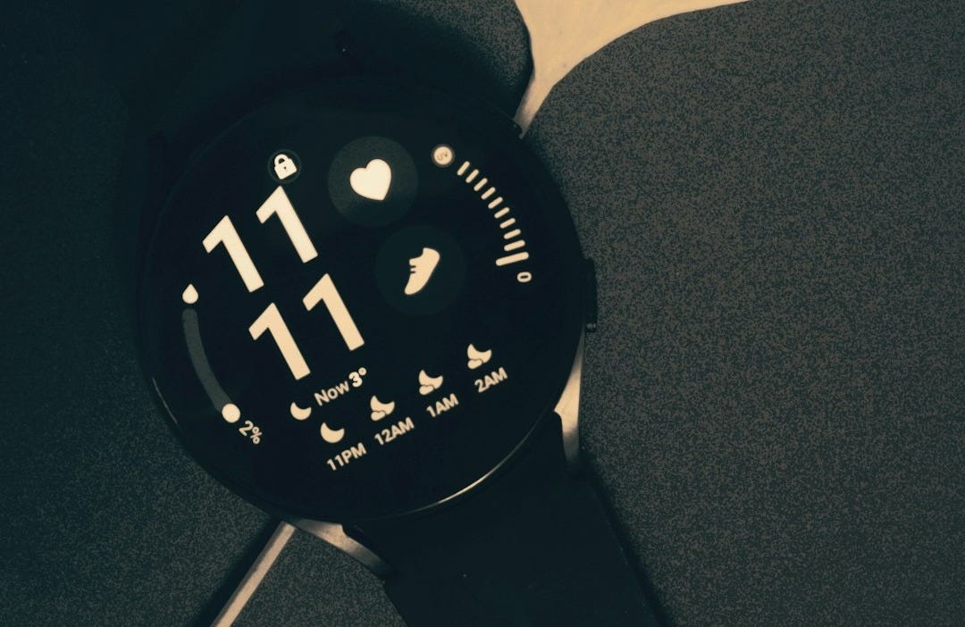 a watch is sitting on a black surface