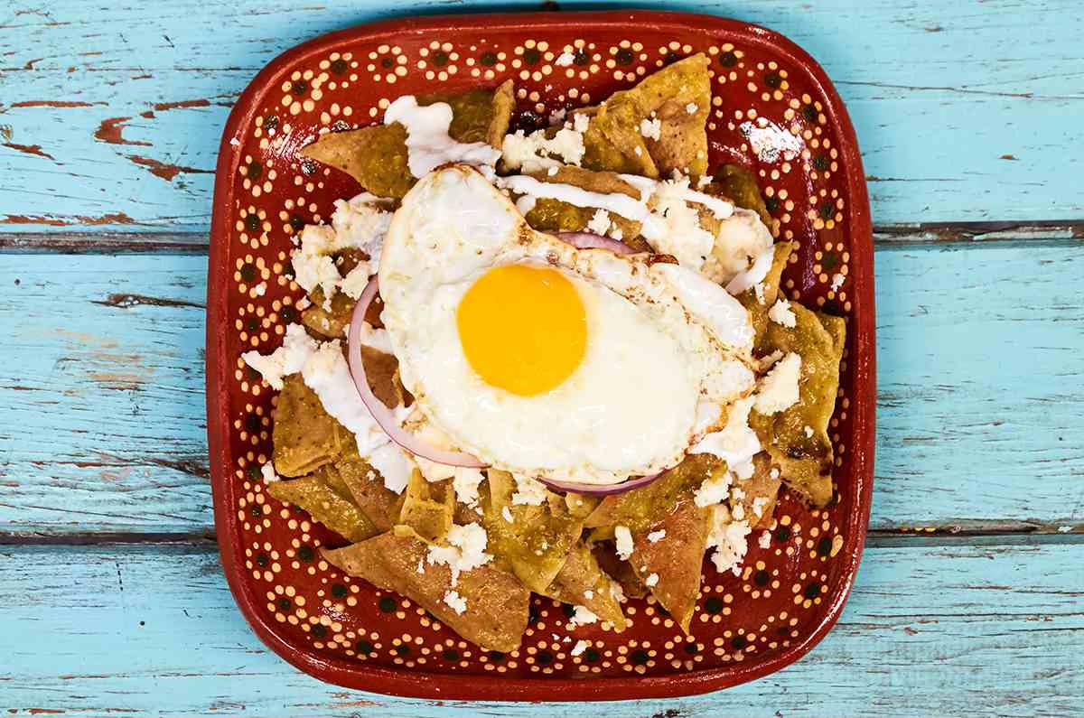 plate of chilaquiles verdes topped with a fried egg