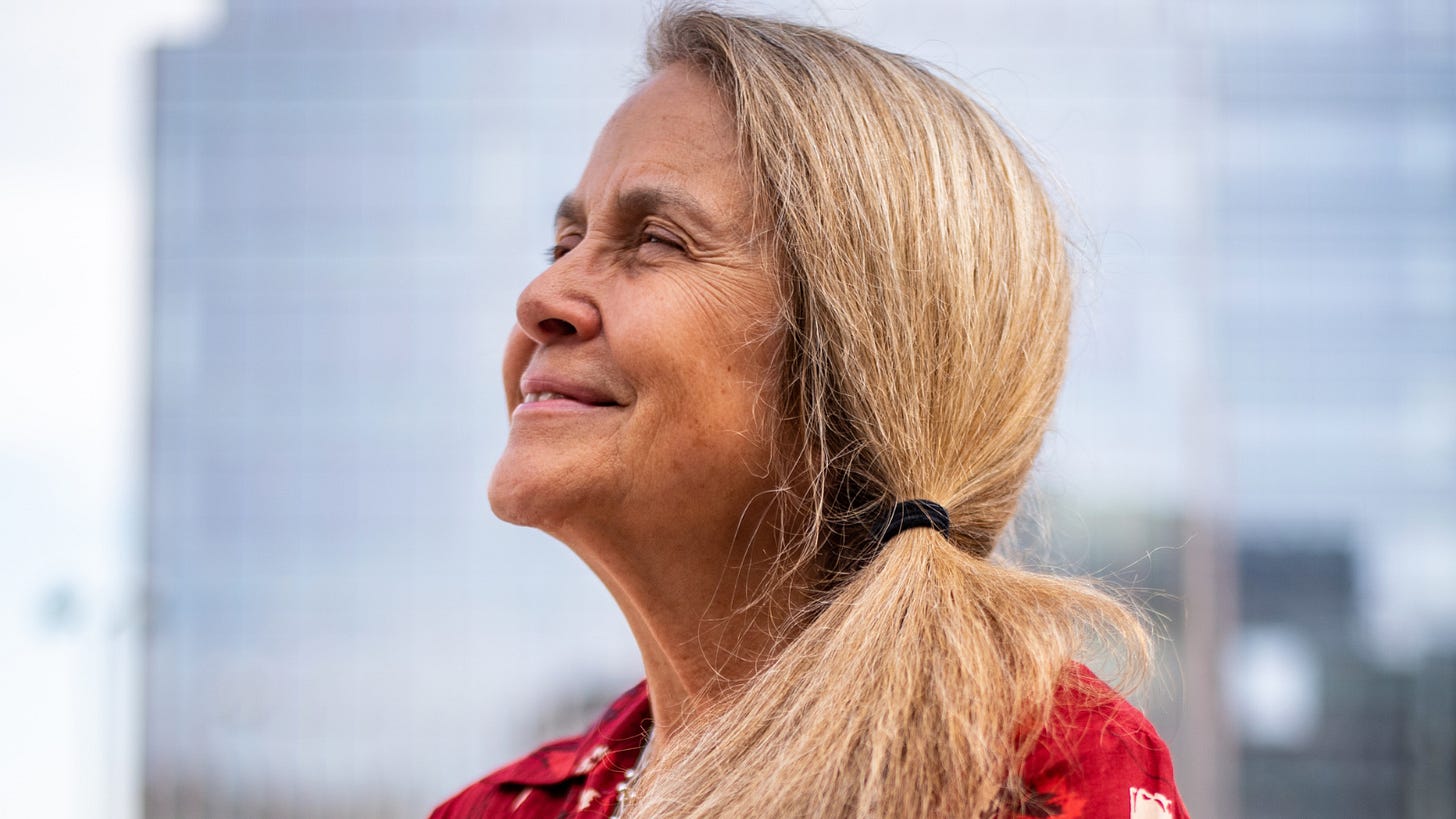 Texas Observer Poetry Editor Naomi Nye poses for a portrait after the Poetry Out Loud competition at Texas Spirit Theater in the Bullock Texas State History Museum on Saturday, March 11 in Austin, TX. She's an older woman wearing a red dress with an autumn leaf pattern, and her blonde hair hair in a side pony tail. Texas Observer Poetry Editor Naomi Nye poses for a portrait after the Poetry Out Loud competition at Texas Spirit Theater in the Bullock Texas State History Museum on Saturday, March 11 in Austin, TX. She's an older woman wearing a red dress with an autumn leaf pattern, and her blonde hair hair in a side pony tail.