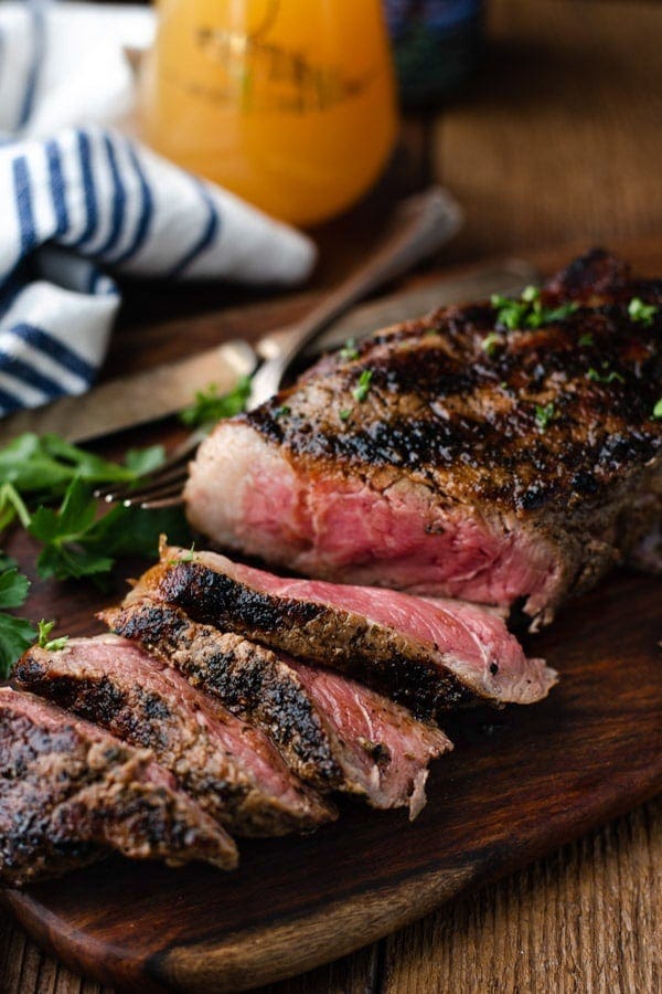 A sliced grilled New York Strip steak on a cutting board