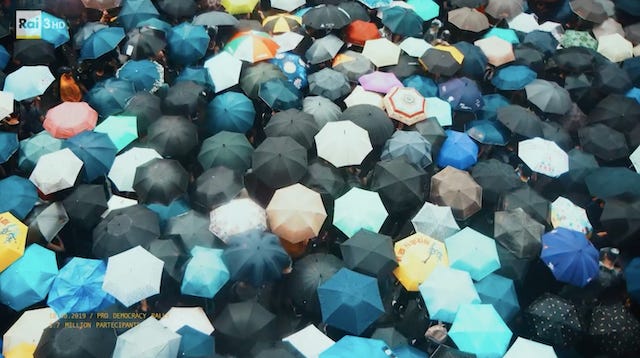 Una folla di persone per le strade di Hong Kong, riprese dall'alto: si vedono solamente i loro ombrelli Una folla di persone per le strade di Hong Kong, riprese dall'alto: si vedono solamente i loro ombrelli
