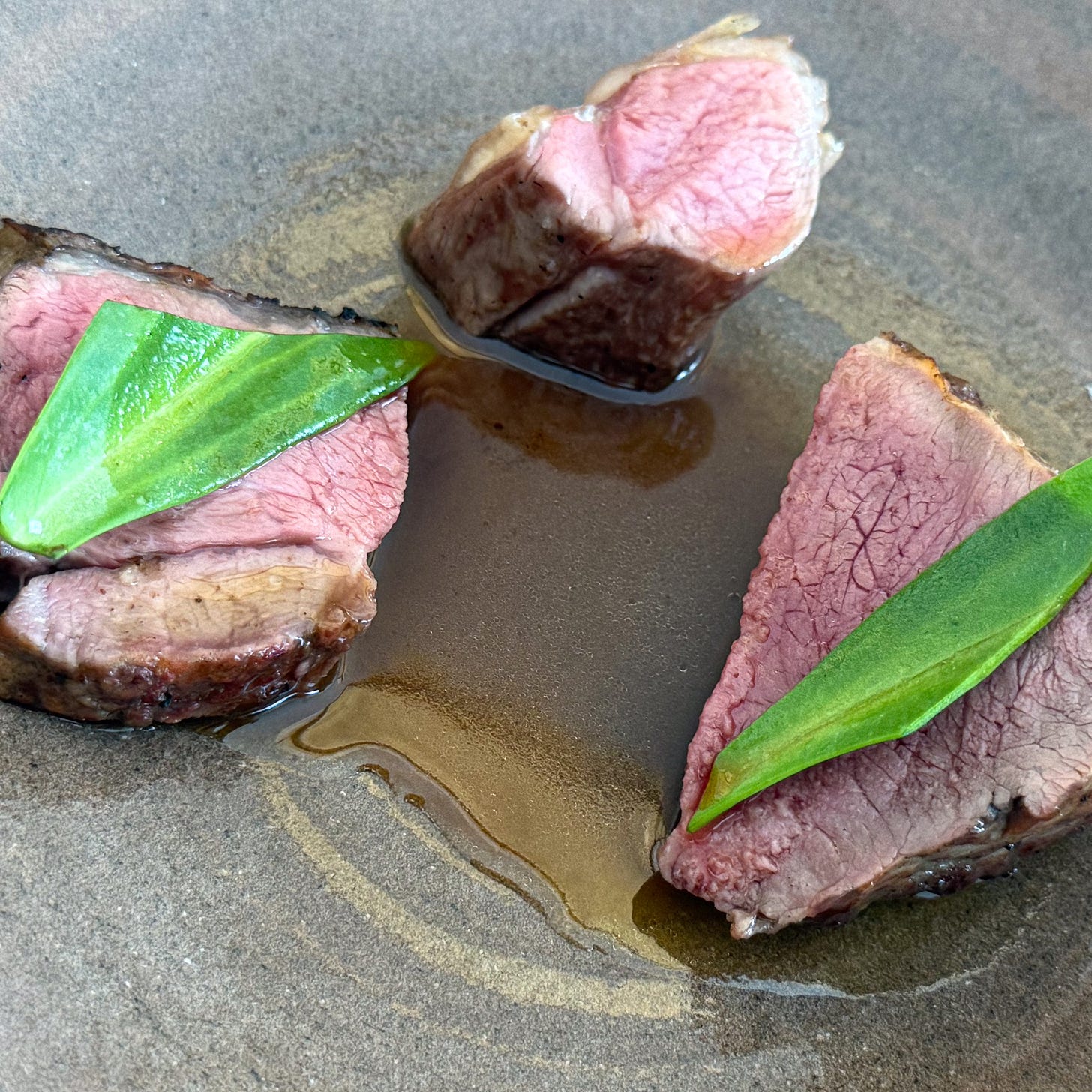 Slices of grilled lamb topped with ramp leaves in a lamb-liver jus at Bittikesu, Paris 4th Slices of grilled lamb topped with ramp leaves in a lamb-liver jus at Bittikesu, Paris 4th