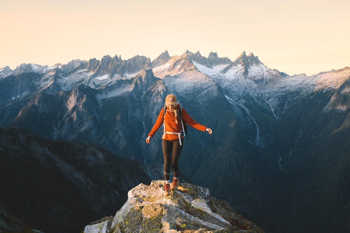 Female hiker celebrating after reaching the summit of a mountain. Female hiker celebrating after reaching the summit of a mountain.