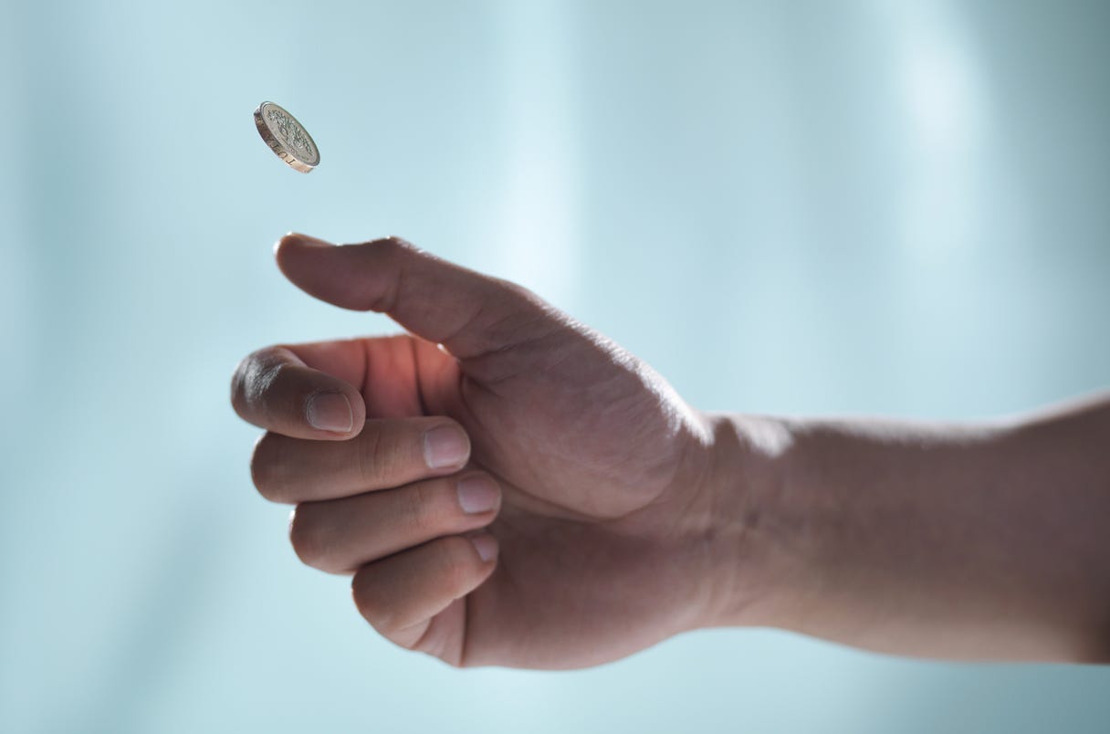 Photograph of a hand flipping a coin