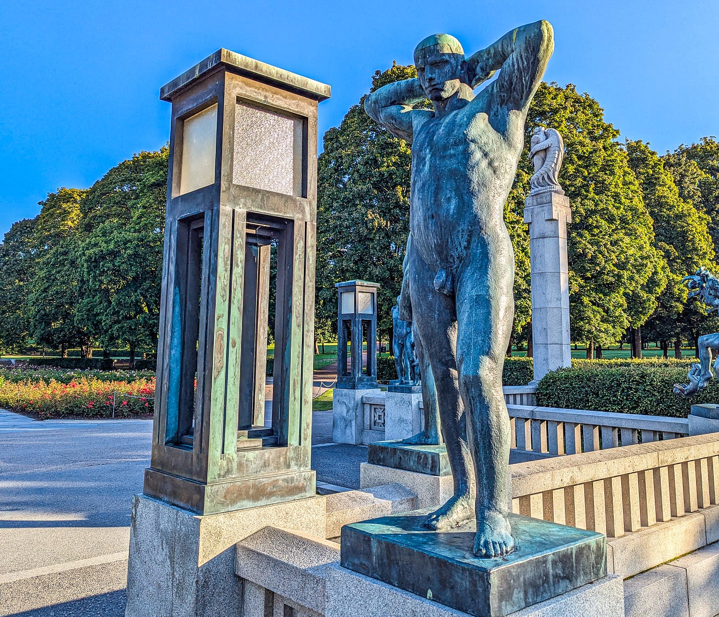 Sculpture of naked man on bridge, hands behind his head as he poses. 