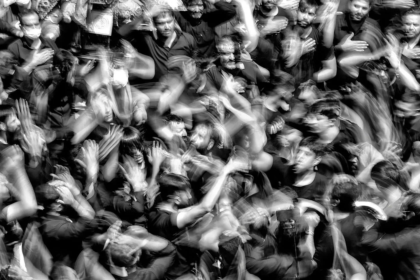 Black and white, top-down photo of a concert croud with hands in the air Black and white, top-down photo of a concert croud with hands in the air