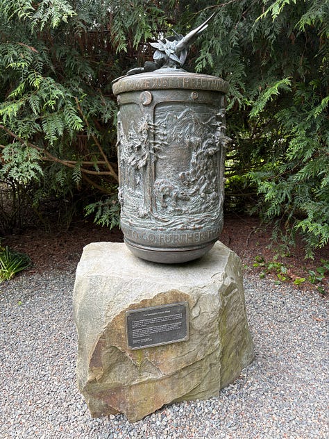 forest setting with labyrinth, brass prayer wheel, and bridge made from a tree