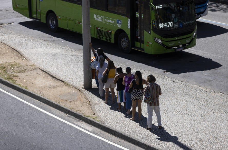 Passageiros procuram se proteger do sol quente na sombra de um poste em ponto de ônibus da Avenida Presidente Vargas, na Cidade Nova