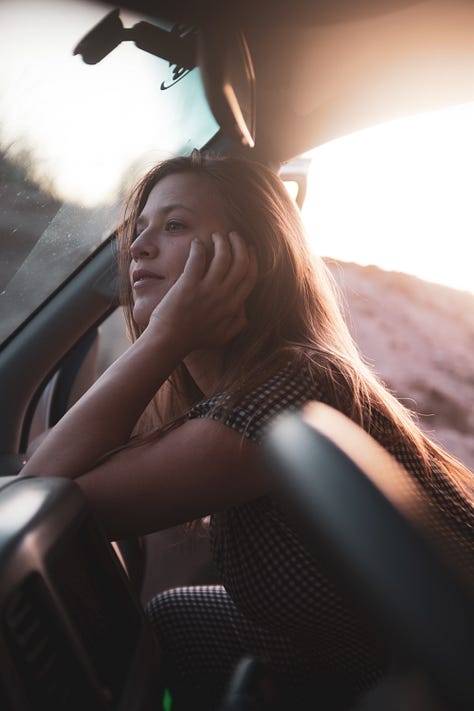 A gallery collage of eight photos from a cross-country road trip. The images show a dark-colored Ford Escape in various scenic American landscapes, including mountains, open plains at sunset, and on the road. The gallery also includes details from the journey and a view from inside the car.