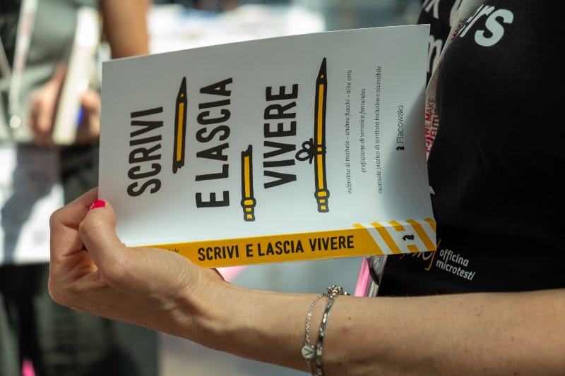 La mano con le dita smaltate di rosso di Valentina regge una copia di Scrivi e lascia vivere.
