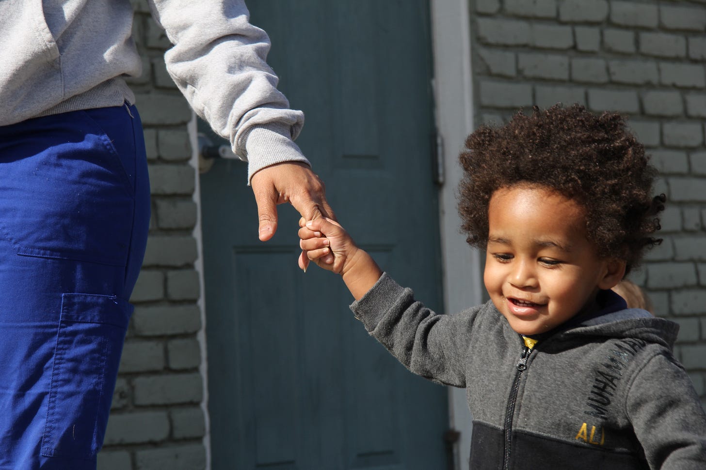 little kid holding the hand of an adult little kid holding the hand of an adult