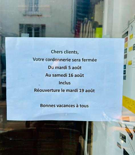 Two signs listing the dates of summer vacation closing times for businesses in France
