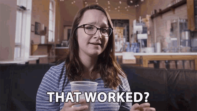 a woman sitting on a couch holding a cup that says that worked on it a woman sitting on a couch holding a cup that says that worked on it