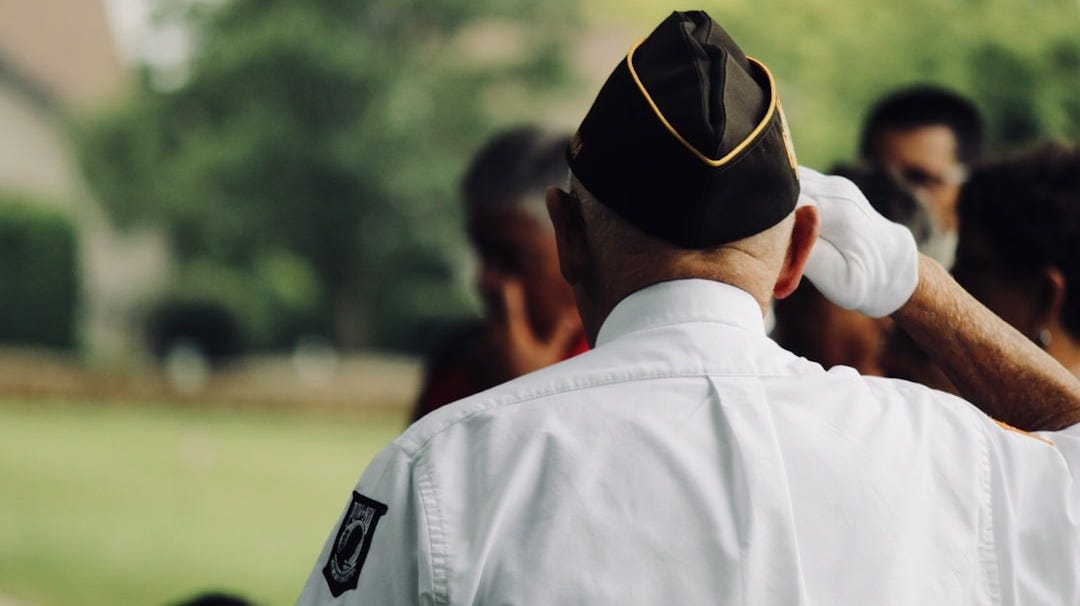 man wearing white uniform saluting