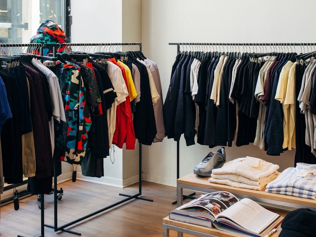 assorted-color clothes hanging on metal racks assorted-color clothes hanging on metal racks