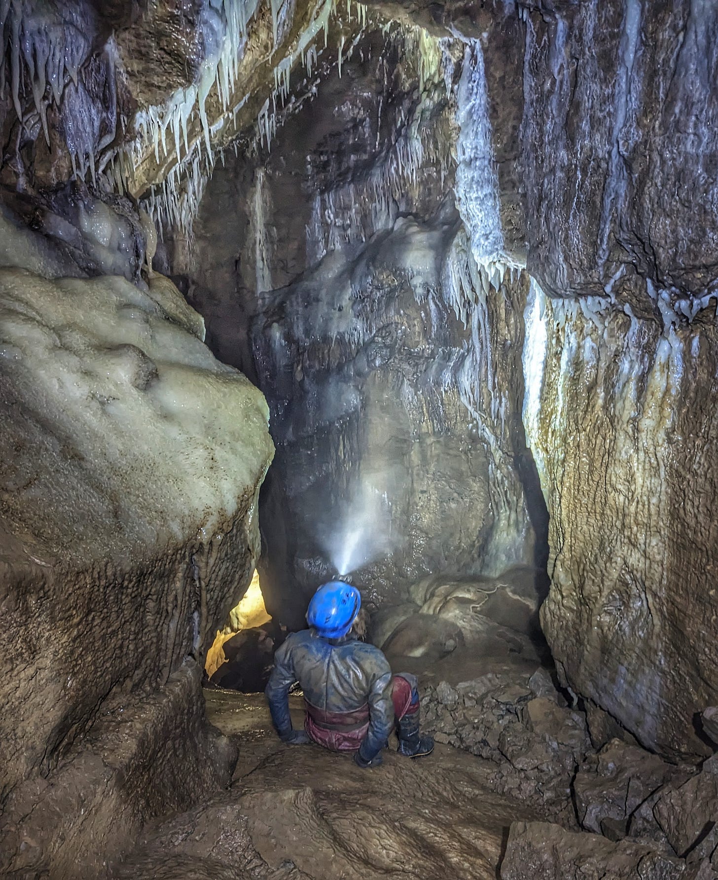 Picture of a caver examining rock formations in Peak Cavern, Castleton