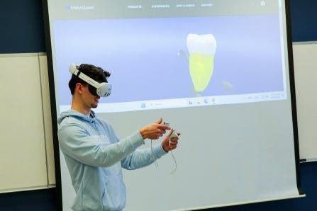 A dental student uses AR goggles to examine a tooth. 