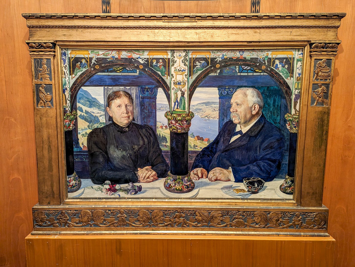Painting of an elderly, kindfaced couple at a table