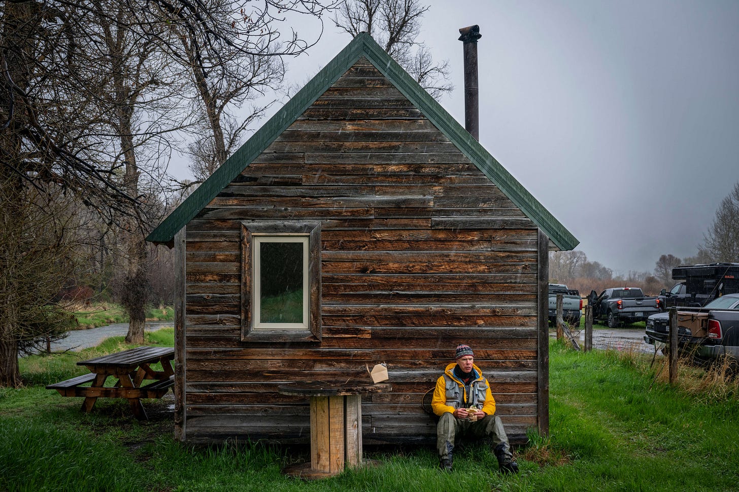 John Juracek sitting on the ground at the spring creeks near Livingston, MT.
