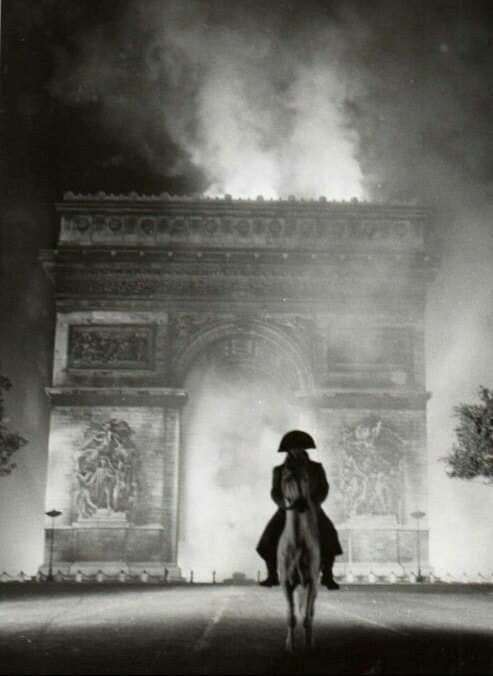 This may contain: black and white photograph of a person on a horse in front of the arc de trioe
