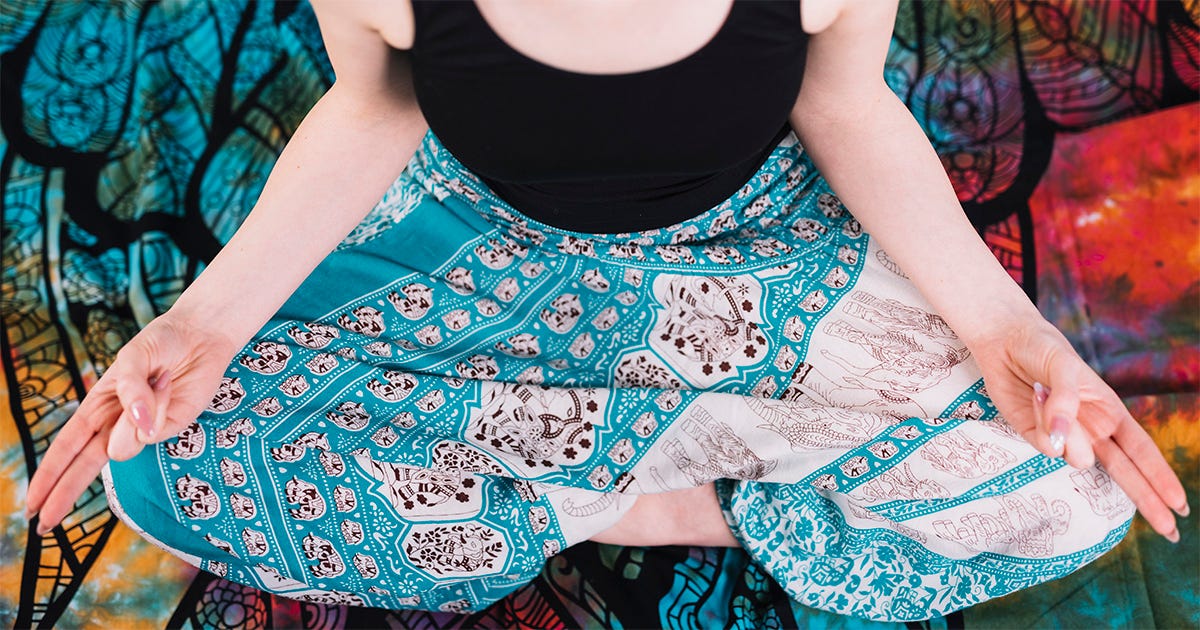 Detalhe do corpo de uma mulher, exibindo do pescoço às pernas, sentada em pose de lotus, em um ambiente desenhado com temas de yoga Detalhe do corpo de uma mulher, exibindo do pescoço às pernas, sentada em pose de lotus, em um ambiente desenhado com temas de yoga