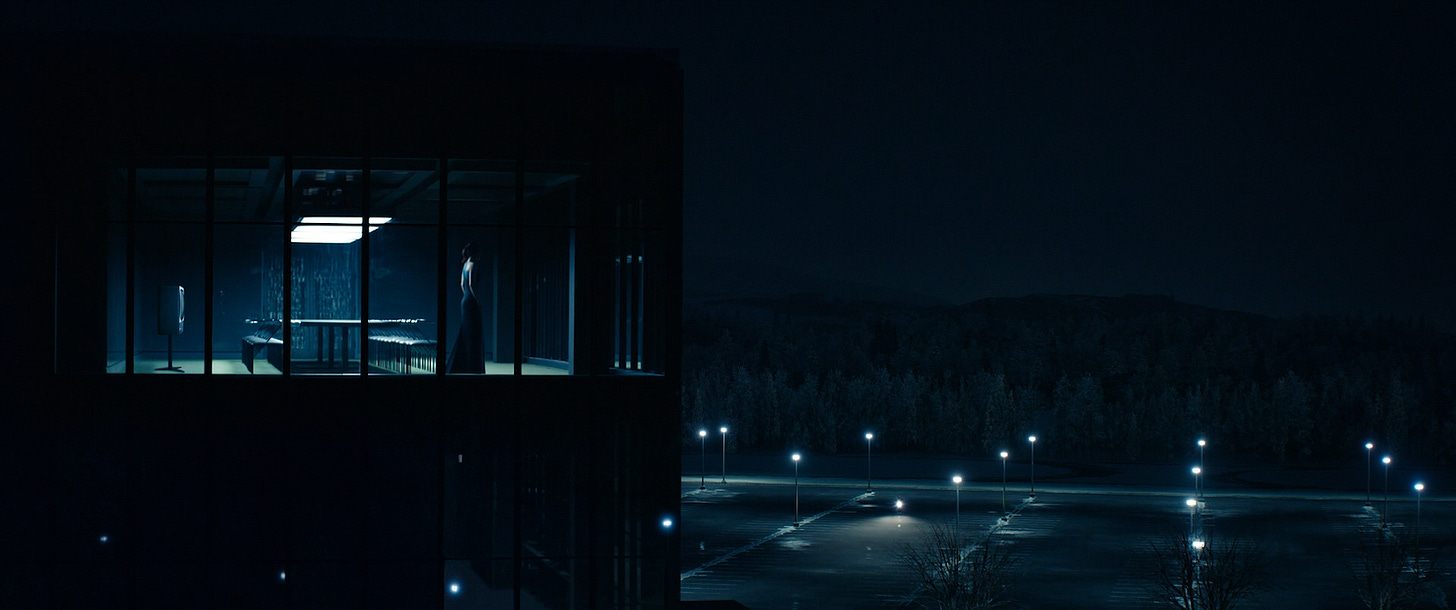 Helena Eagan standing inside the Lumon building looking out at the parking lot