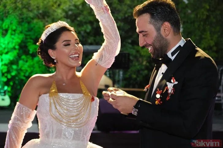 Ferit Kaya'nın düğün töreninden mutlu bir an. Siyah smokin giymiş olan Ferit, beyaz gelinlik içindeki eşi Yasemin Ceren ile birlikte dans ederken görülüyor. Eşi kolunu havaya kaldırmış, ikisi de mutlulukla gülümsüyor.