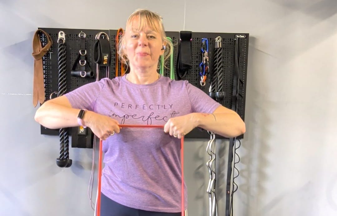 Image of Andrea demonstrating a banded row at the top half of the movement