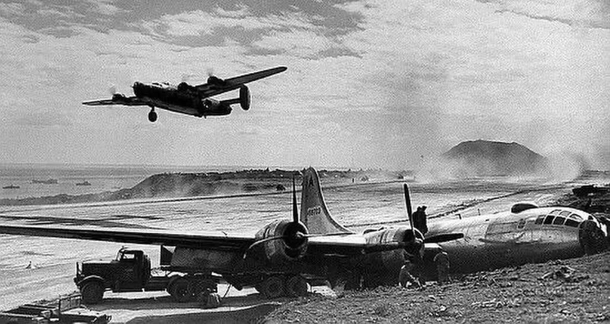 A USAAF Consolidated B-24 Liberator takes off over the wreckage of a Boeing B-29 Superfortress at the recently captured airfield on Iwo Jima during 1945. A USAAF Consolidated B-24 Liberator takes off over the wreckage of a Boeing B-29 Superfortress at the recently captured airfield on Iwo Jima during 1945.