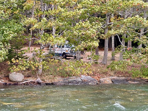 Beach, rocky coast, van at waterfront campsite
