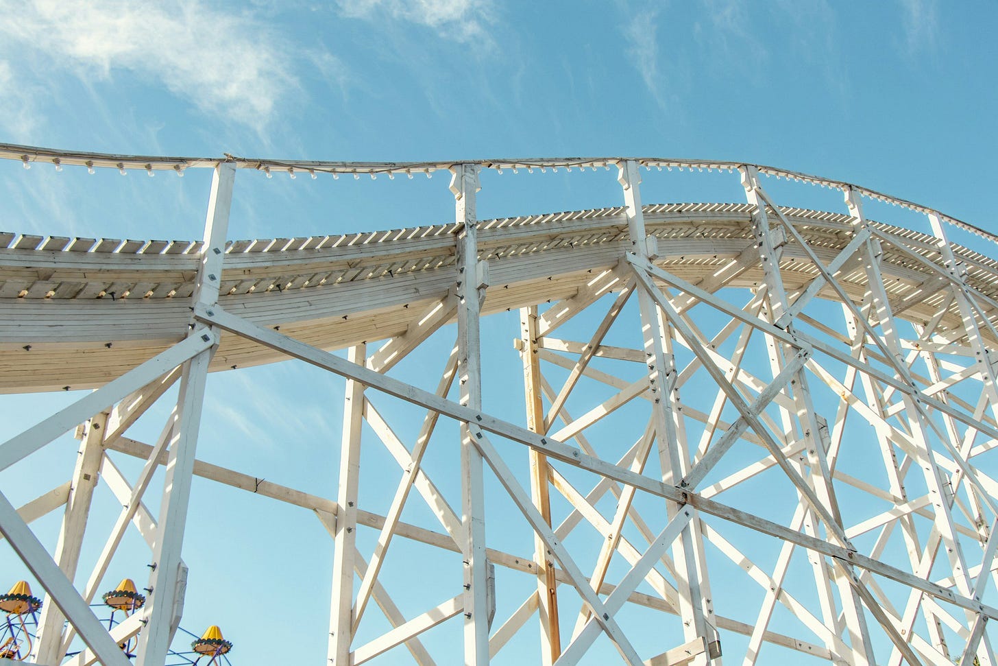 Wooden roller coaster track against blue sky