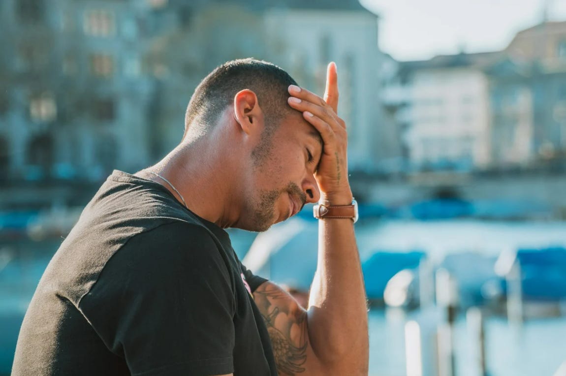 A man on a street overthinking and wondering how to stop overthinking everything and how to not overthink.