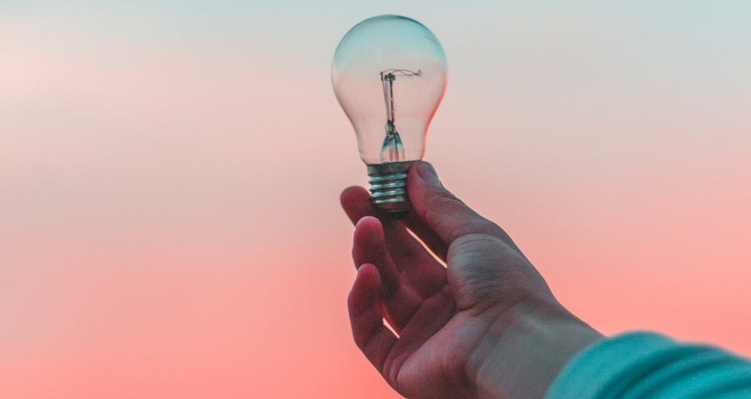 person holding light bulb person holding light bulb