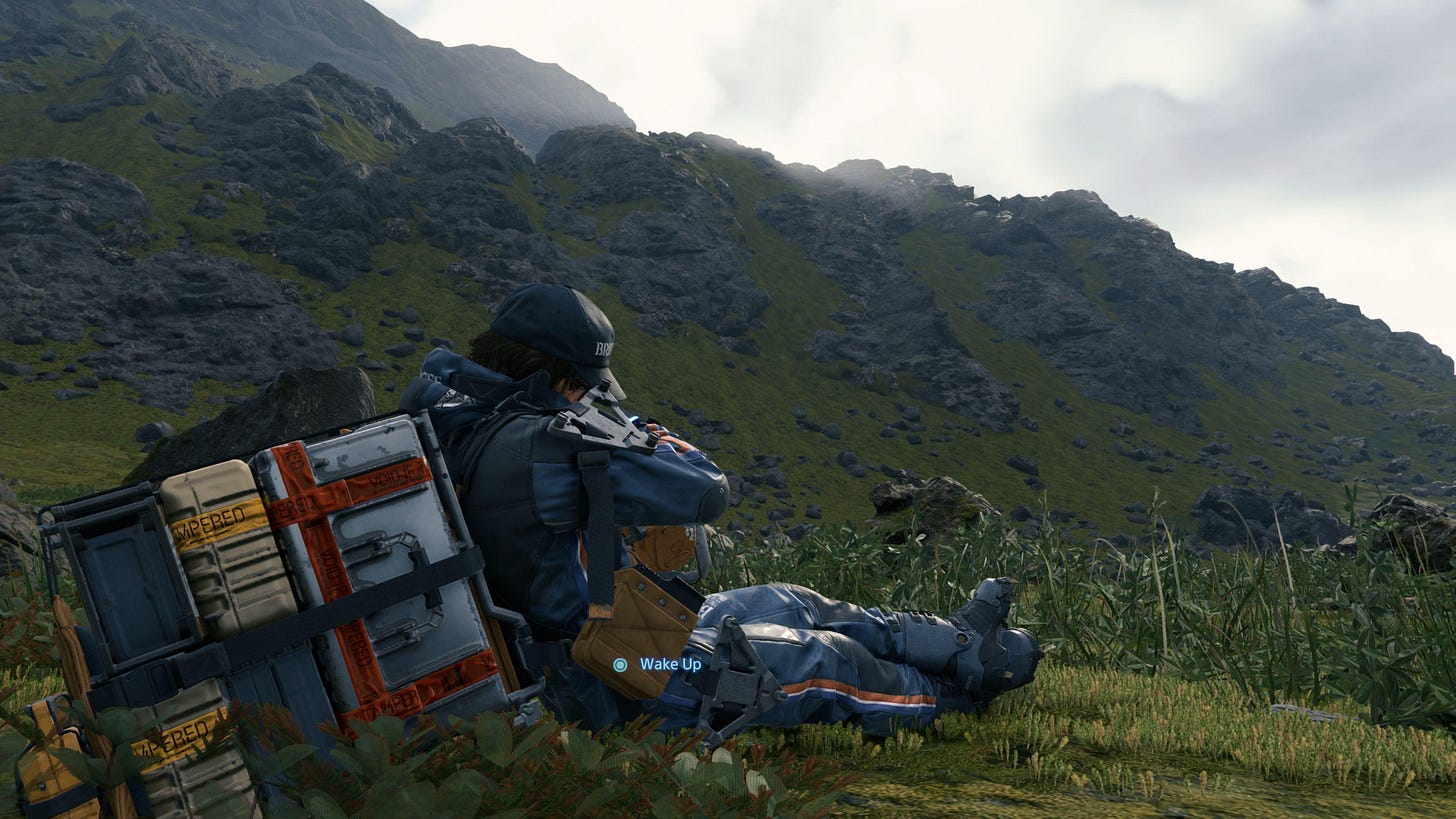 A screenshot of Death Stranding sowing protagonist Sam Porter Bridges resting on the green landscape with his back to the viewer, overlooking some rocky hills