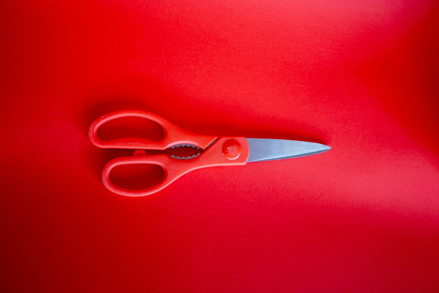 a pair of red-handled scissors on a red background a pair of red-handled scissors on a red background