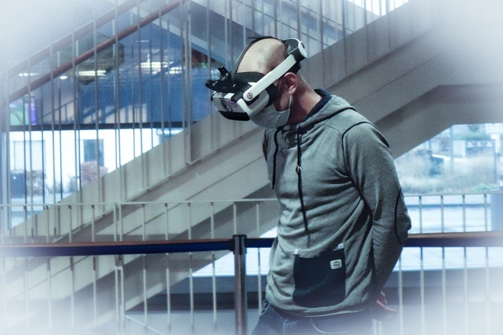a man wearing a VR headset navigates a flight of stairs