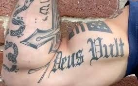 A person's chest with tattoos

Description automatically generated