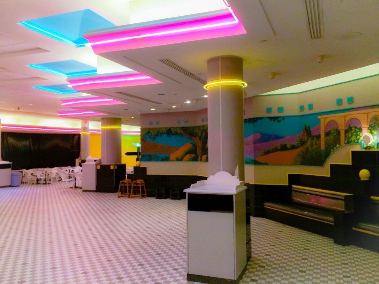 A mall food court with neon lighting.