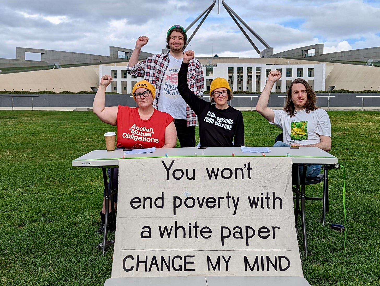 Activists outside Parliament House behind a banner that reads “You won’t end poverty with a white paper”. Activists outside Parliament House behind a banner that reads “You won’t end poverty with a white paper”.