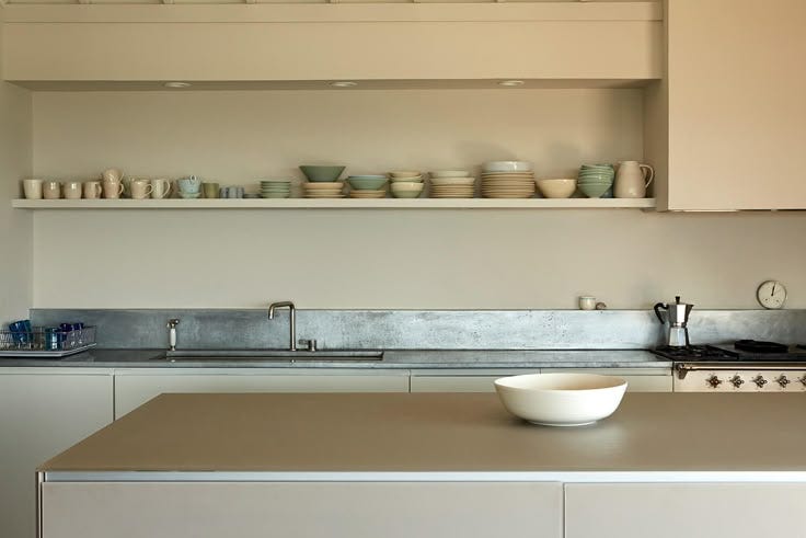 This may contain: a white bowl sitting on top of a kitchen counter next to a shelf filled with dishes