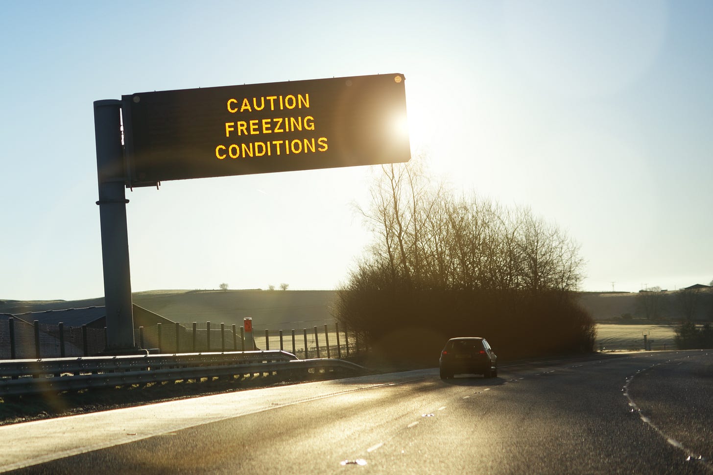 Road sign reading "caution: freezing conditions"