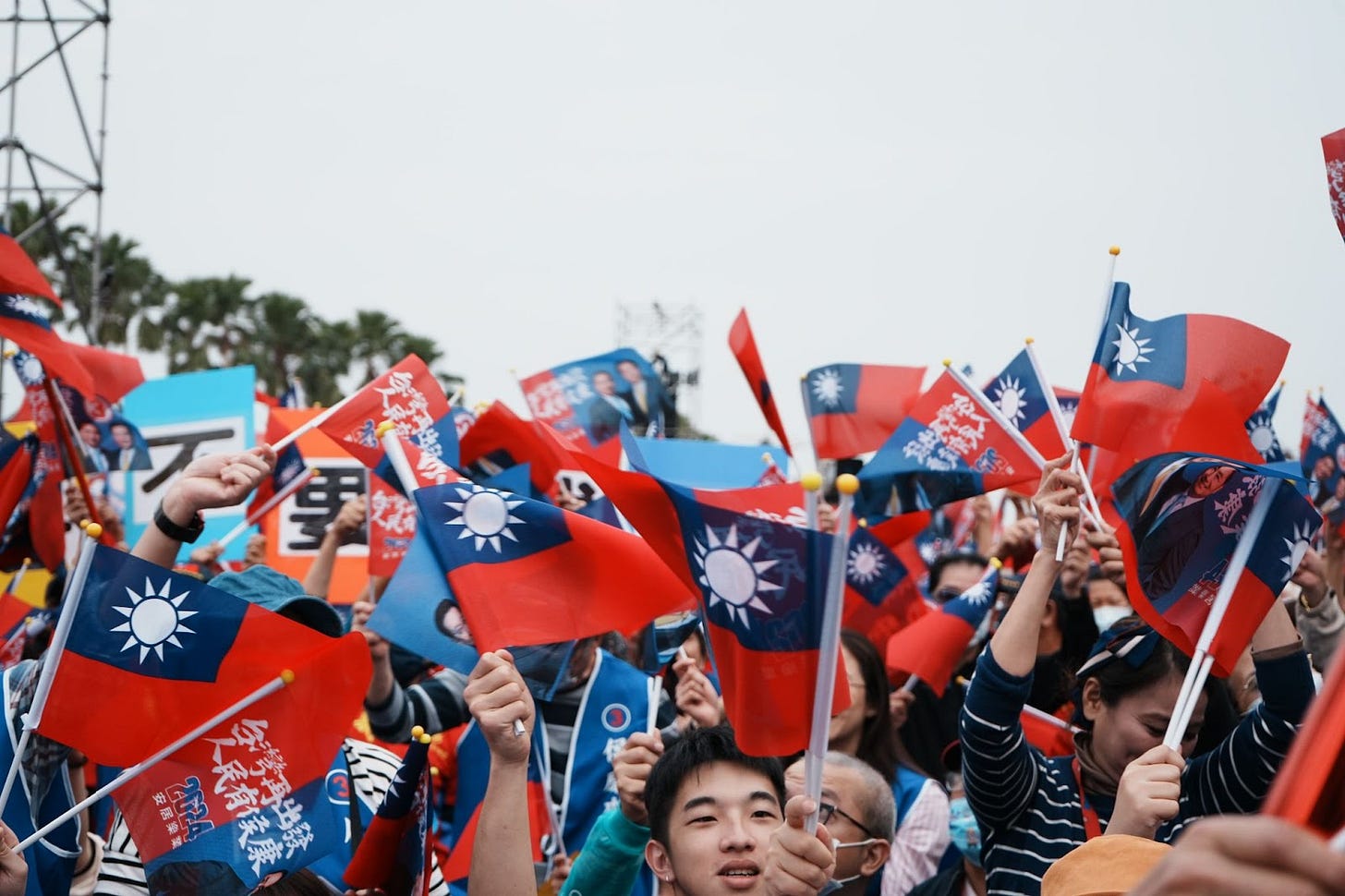 A group of people holding flags

Description automatically generated