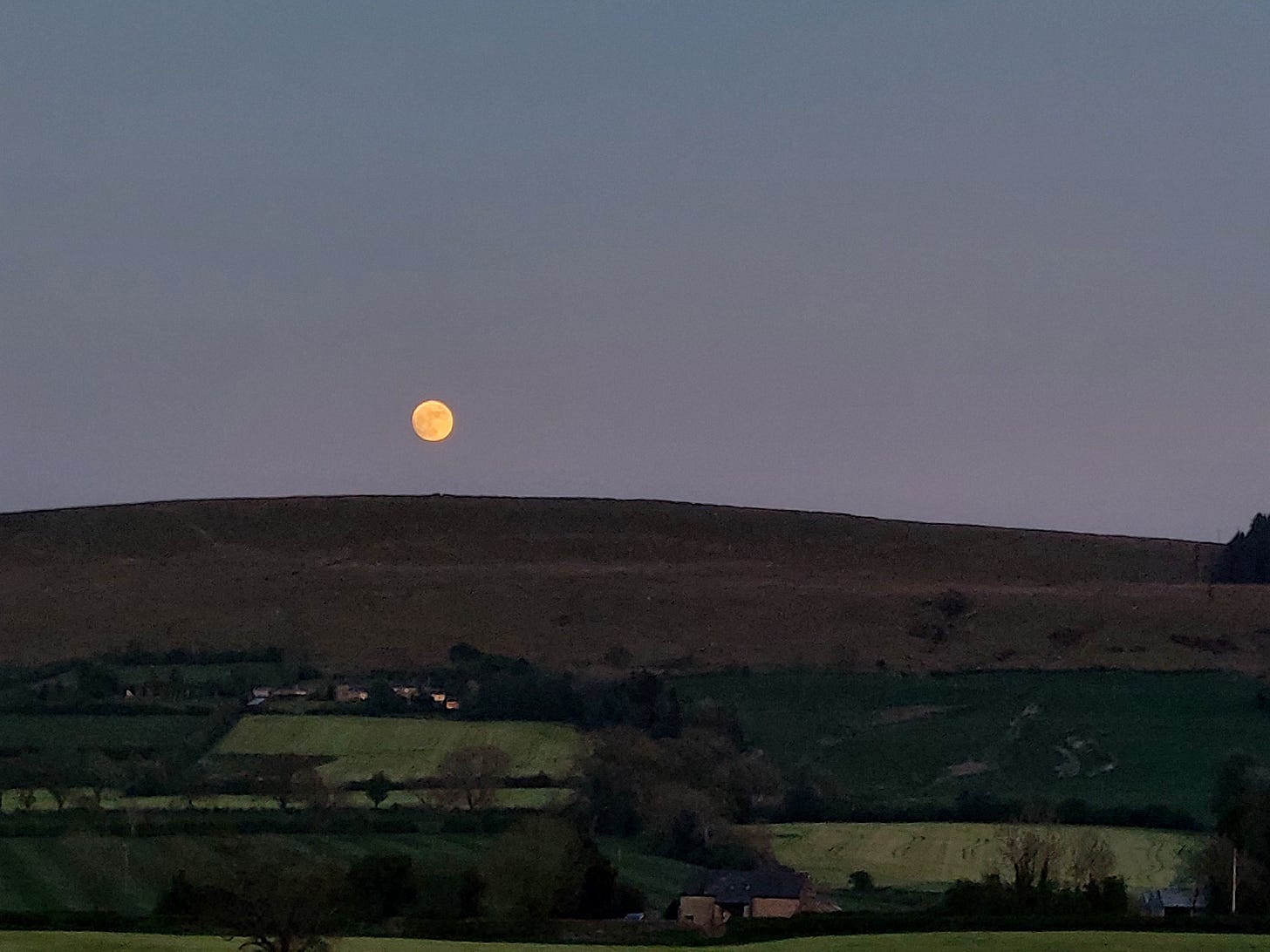 A full moon rise over the fells at dusk A full moon rise over the fells at dusk