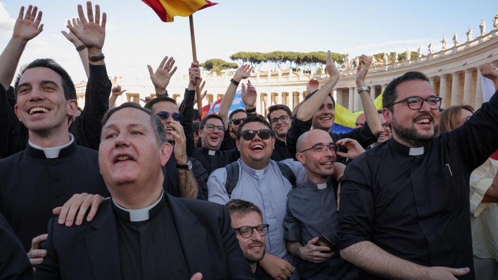 Priests react to white smoke from the chimney on the Sistine Chapel