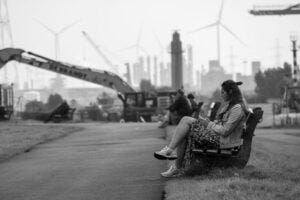 woman sitting on a bench near a construction site