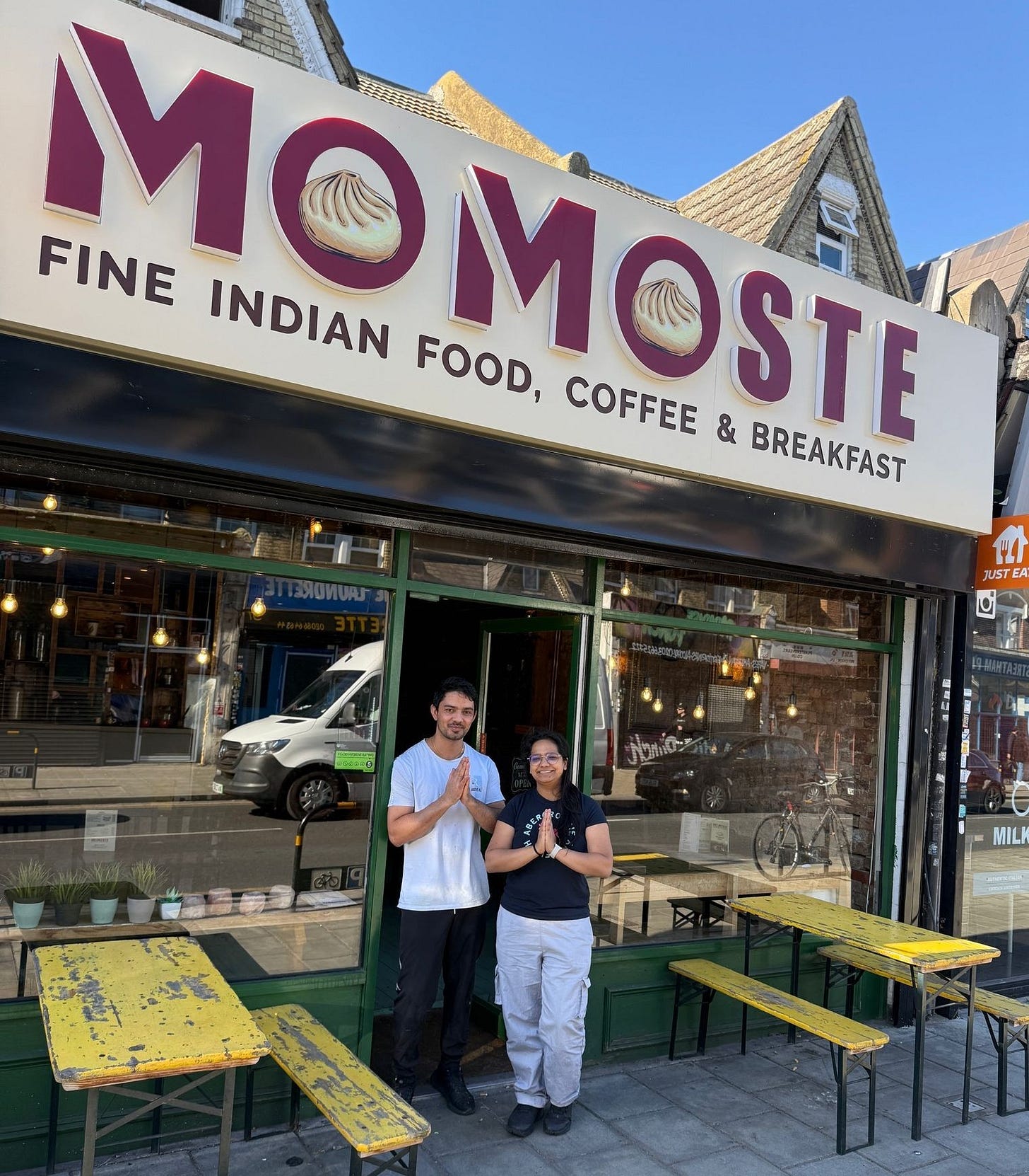May be an image of 2 people and text that says "Co FINE MOMOSE MO INDIAN FOOD, COFFEE MOSTE & BREAKFAST 와 JUSTEAT TEAT JumO MILKS"