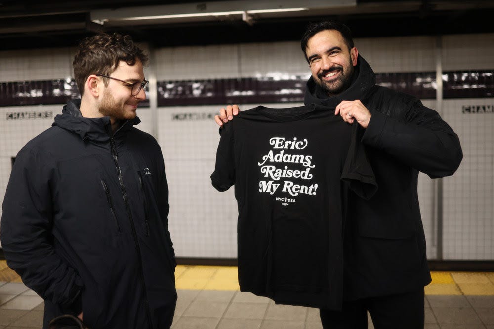 New York City mayoral candidate, State Assemblymember Zohran Mamdani (D-N.Y.) holds up a campaign shirt.